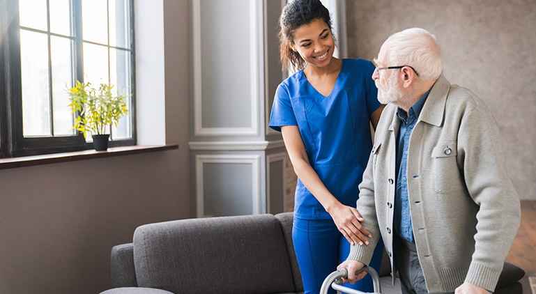 Caregiver assisting an elderly man in a comfortable interior