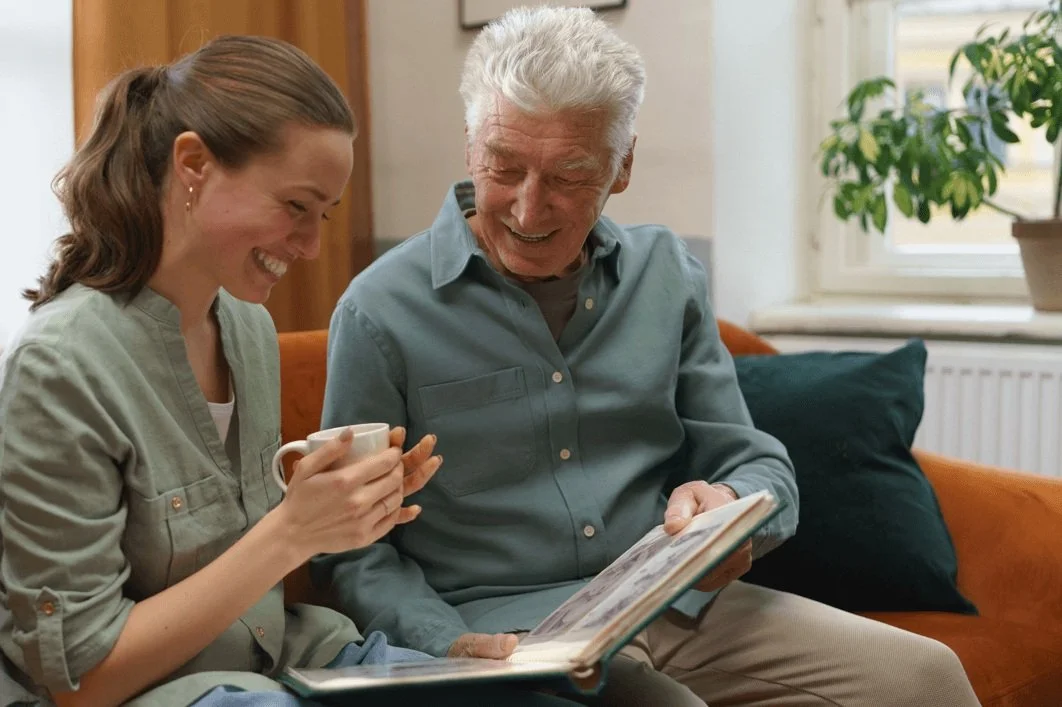 Senior man and caregiver sharing a photo album