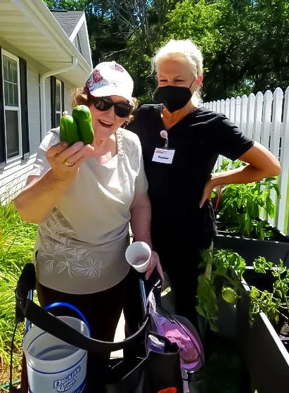 A resident and staff member gardening together.