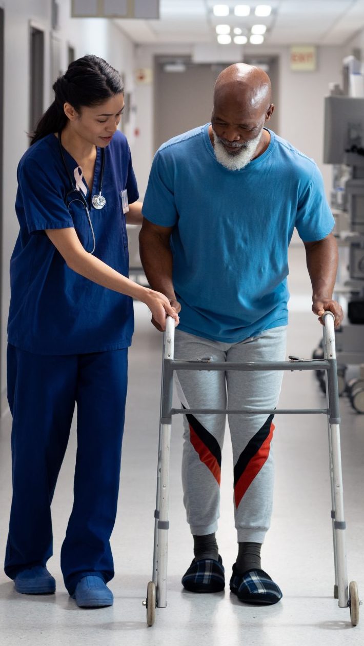 Healthcare professional assisting a patient with a walker