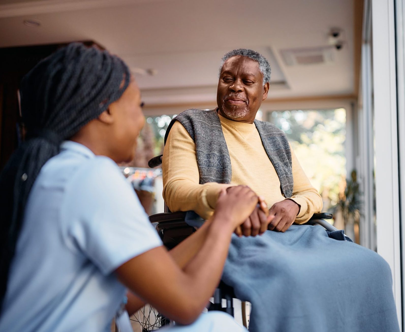 Caregiver talking with a senior resident in a wheelchair.