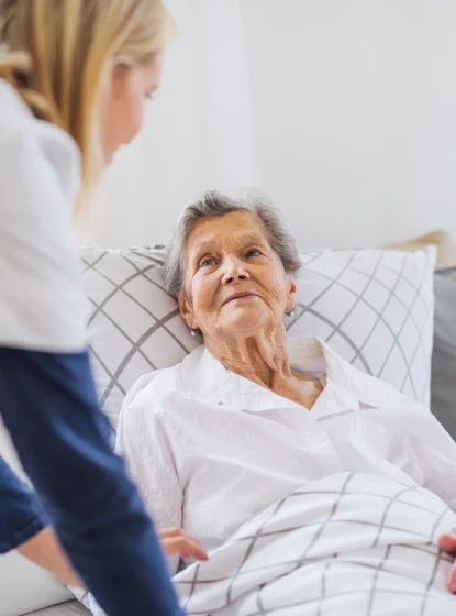 Nurse attending to an elderly resident in bed