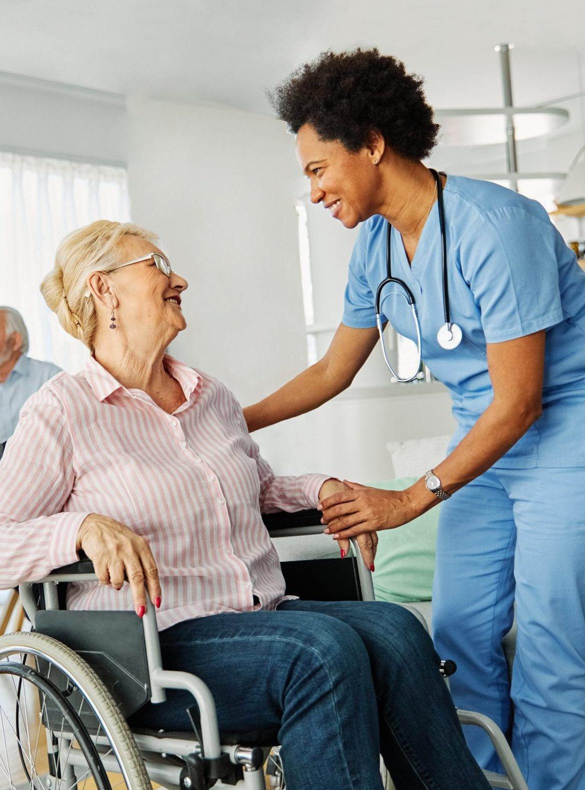 Nurse interacting with elderly resident in a care setting.