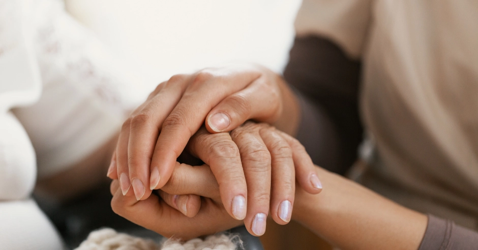 Two hands holding, symbolizing care and support.