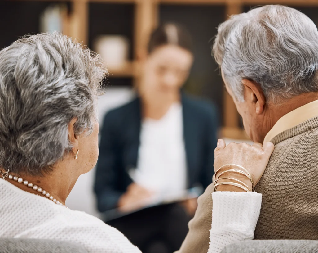 Elderly couple consulting with healthcare professional.