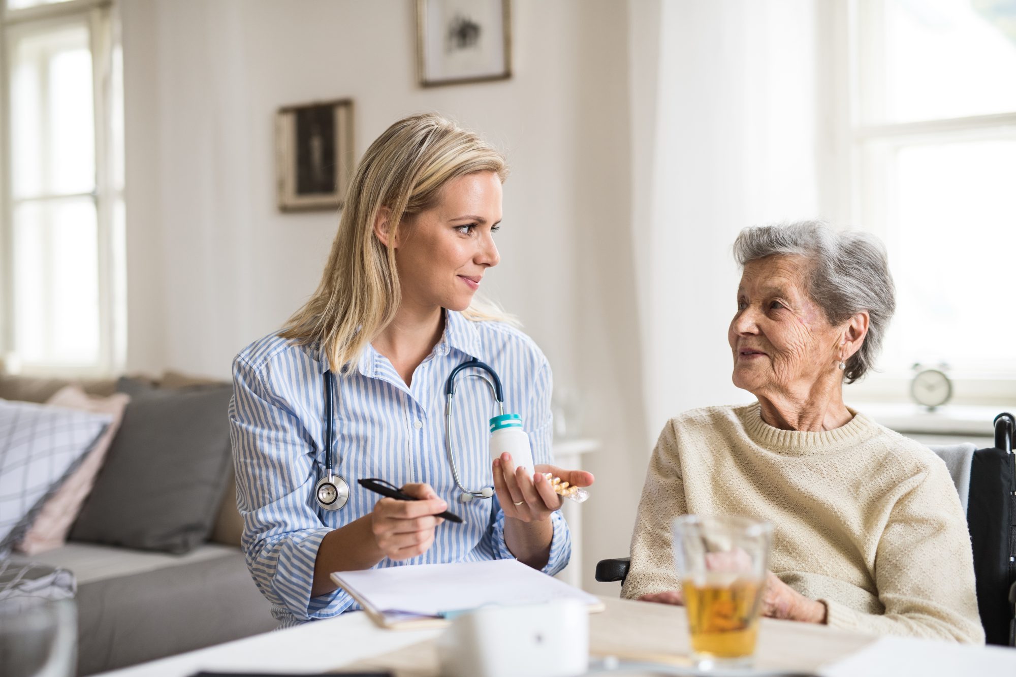 Healthcare professional assisting an elderly woman