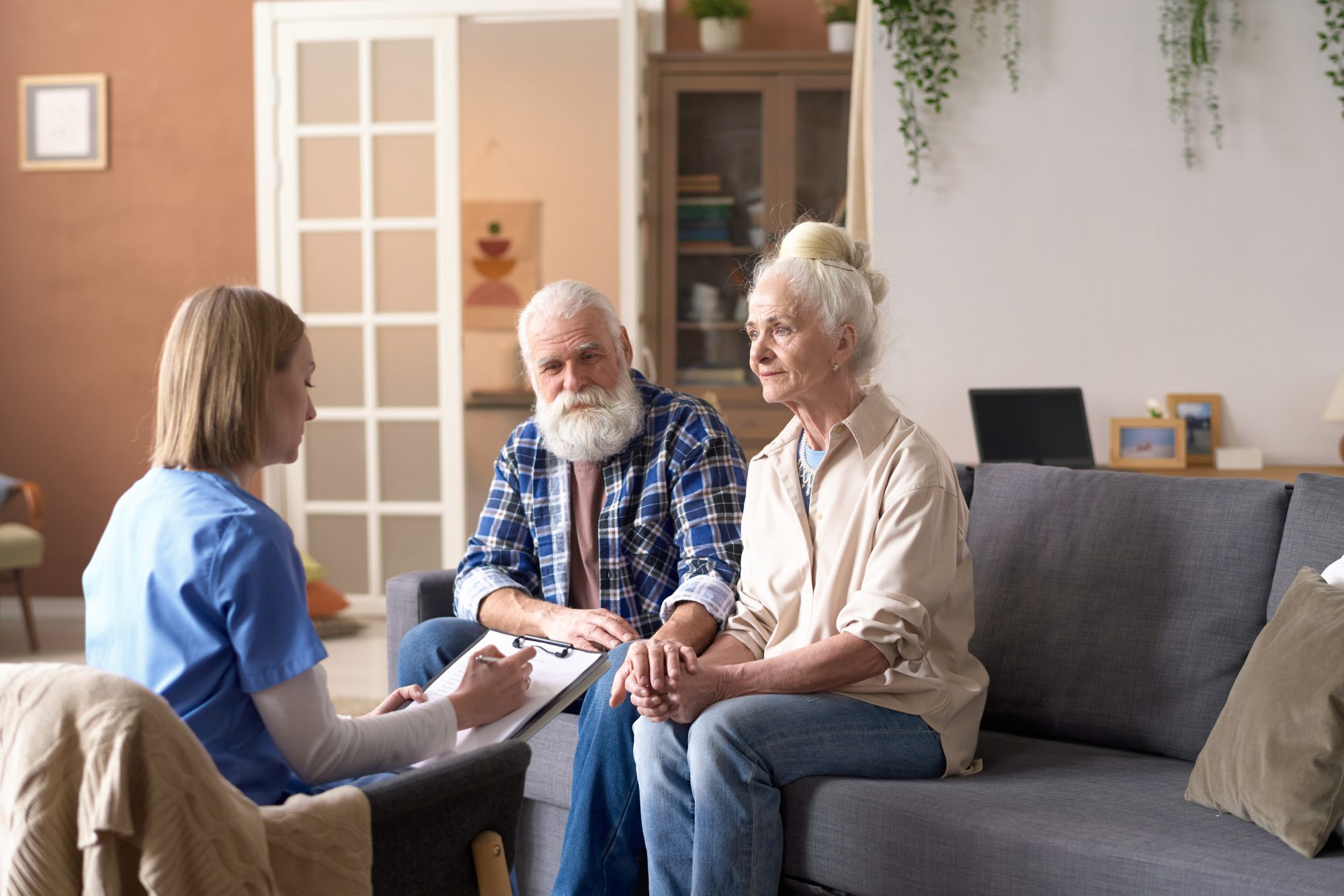Healthcare professional talking with elderly couple.