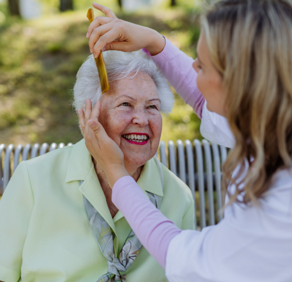 A caregiver and resident enjoying outdoor grooming.