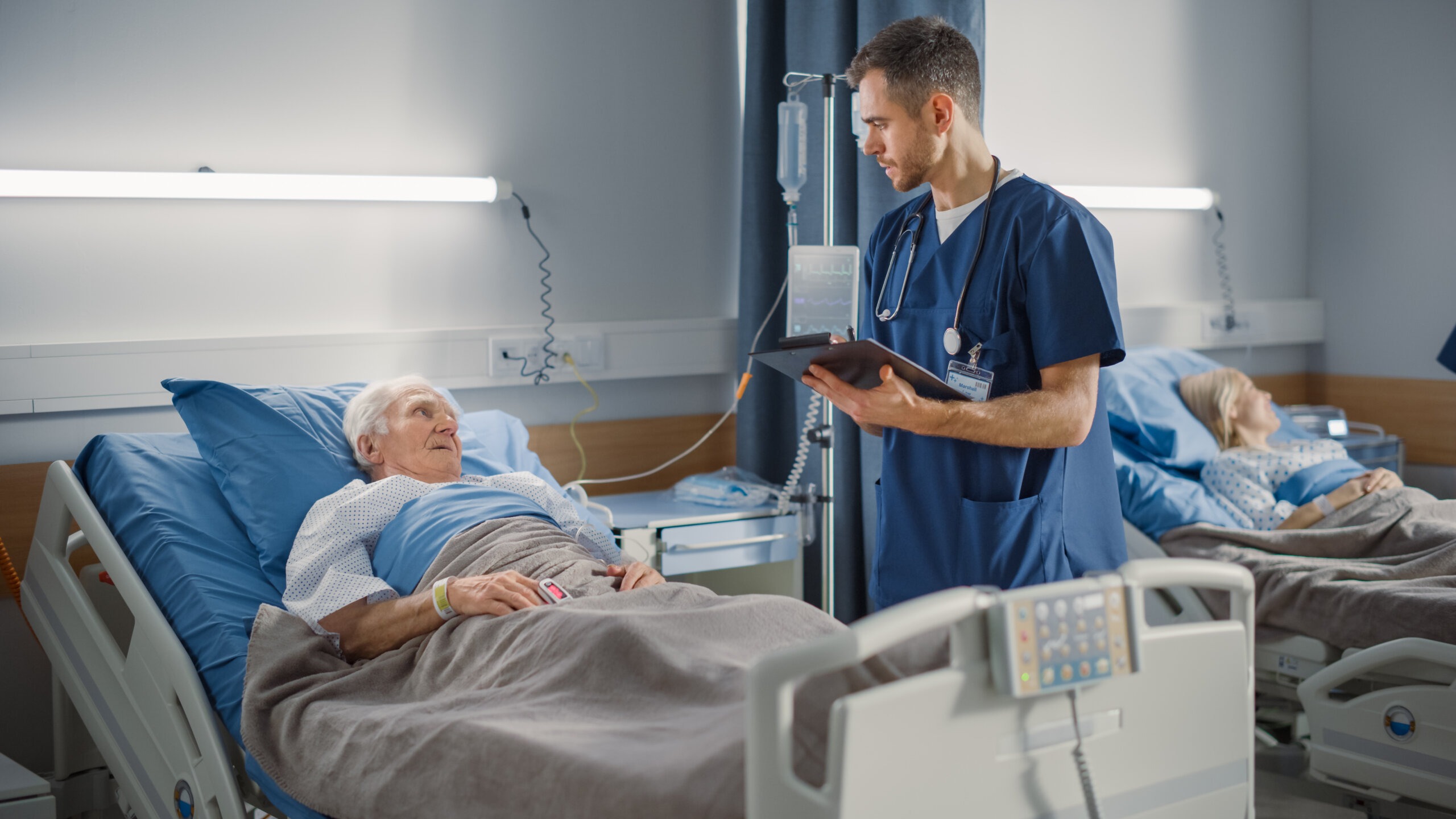 Healthcare professional interacting with elderly patient in hospital