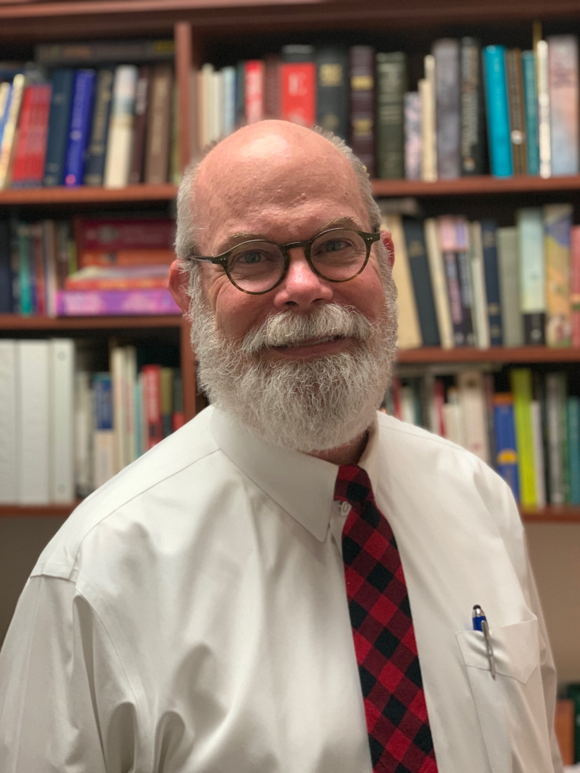 Smiling man in front of bookshelf