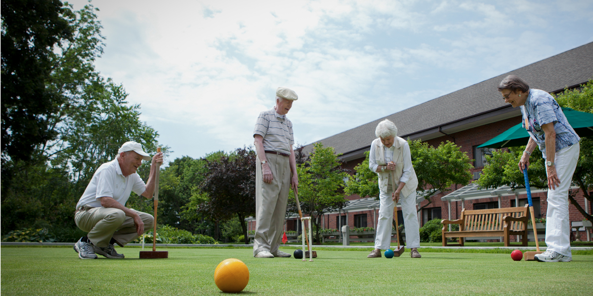 Residents participating in outdoor croquet activity.