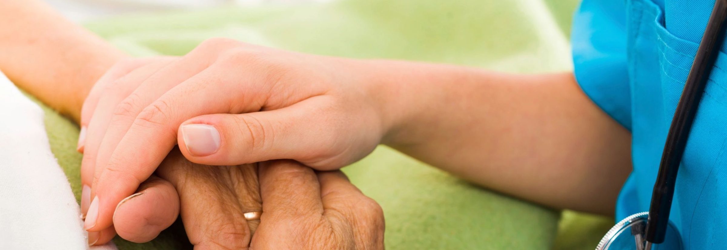 Close-up of hands between caregiver and resident