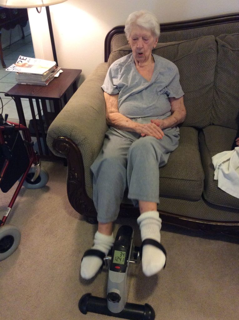 Elderly resident using a pedal exercise machine.