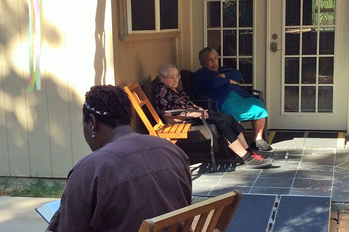 Two residents relaxing outside on a patio.