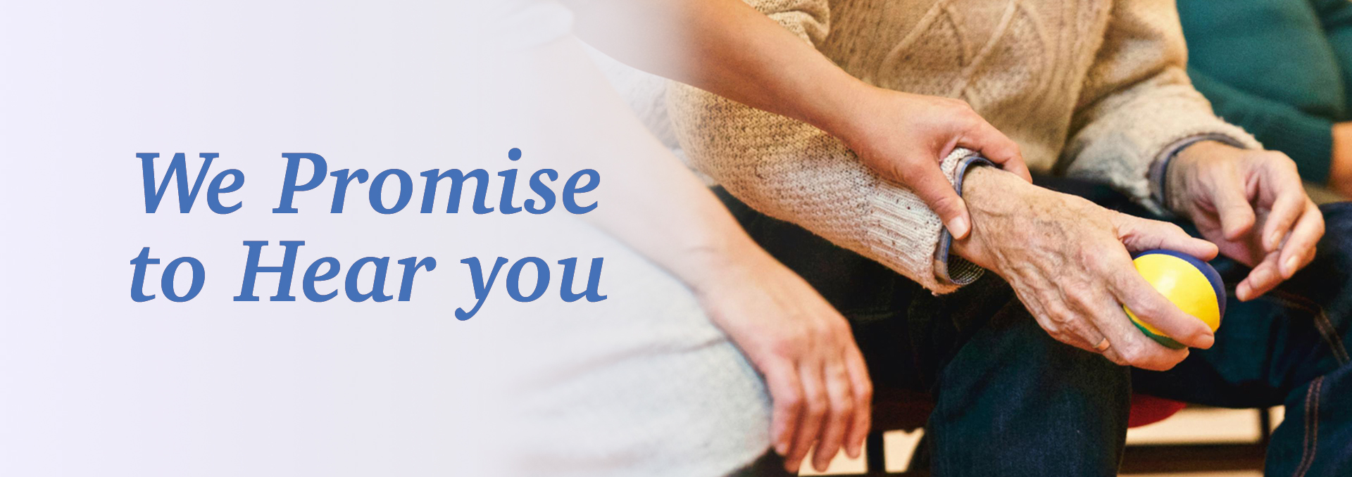Hands of a caregiver and senior holding a ball.