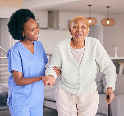 Healthcare worker assisting an elderly resident indoors.