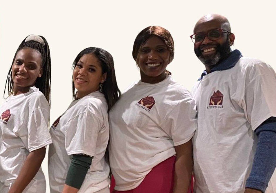 Staff members wearing branded shirts and smiling