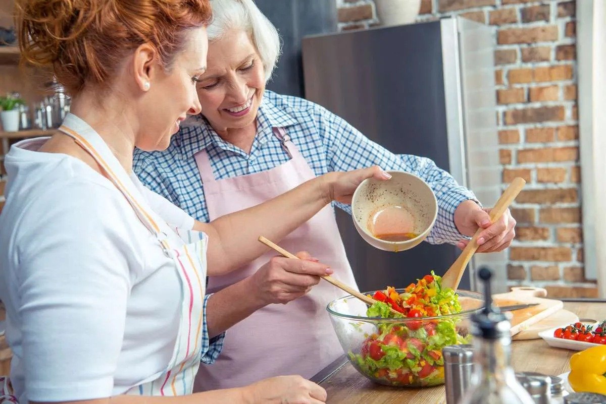 Two women preparing a fresh salad together