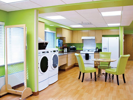 Bright kitchen area with green walls and appliances.