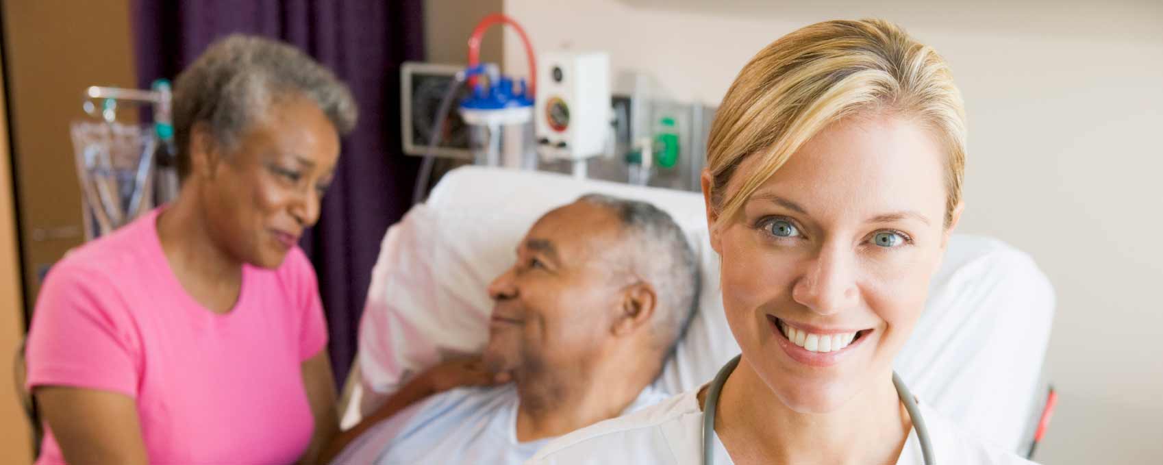 Healthcare worker smiling with patients in a room.