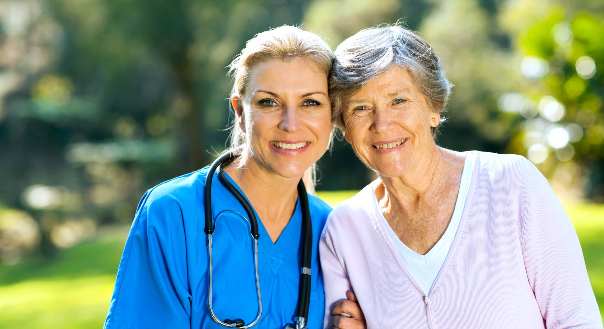Smiling staff member with a resident outdoors