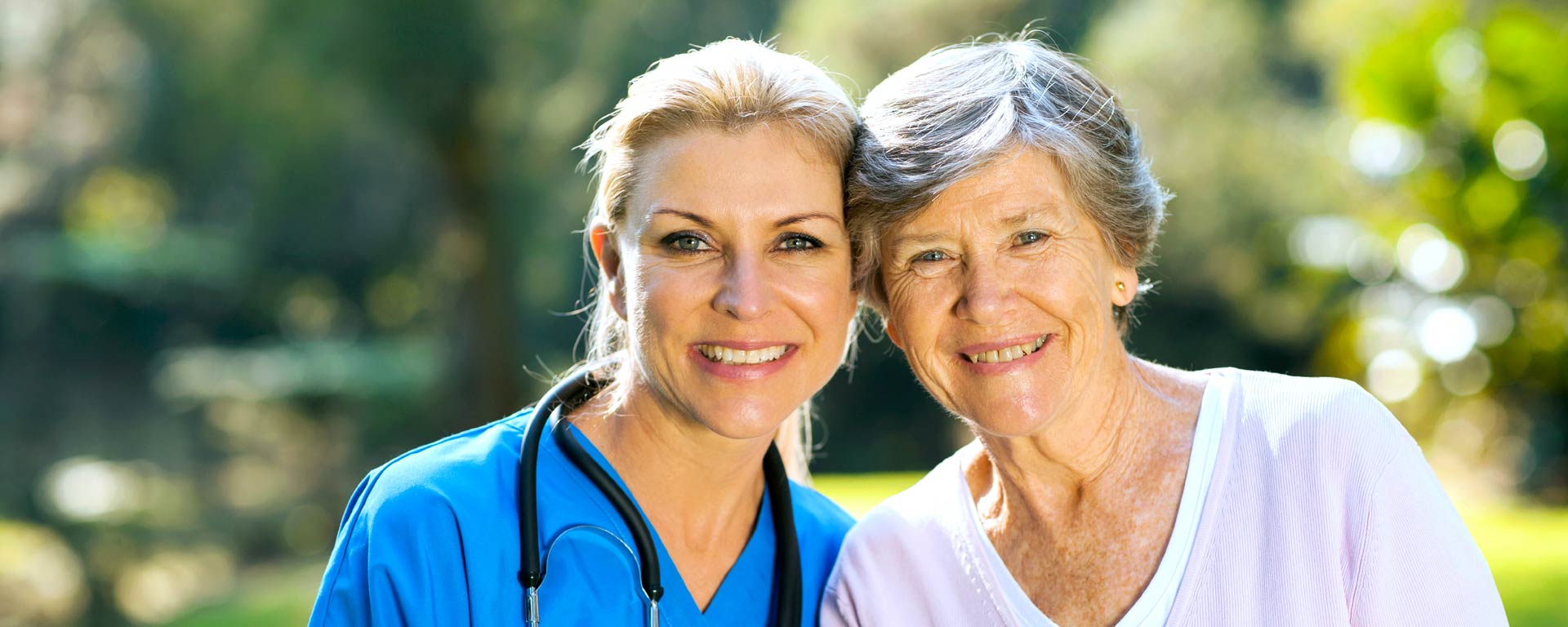Healthcare worker with senior resident outdoors.