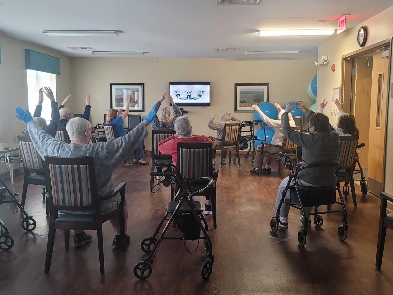 Residents participating in a seated exercise class indoors