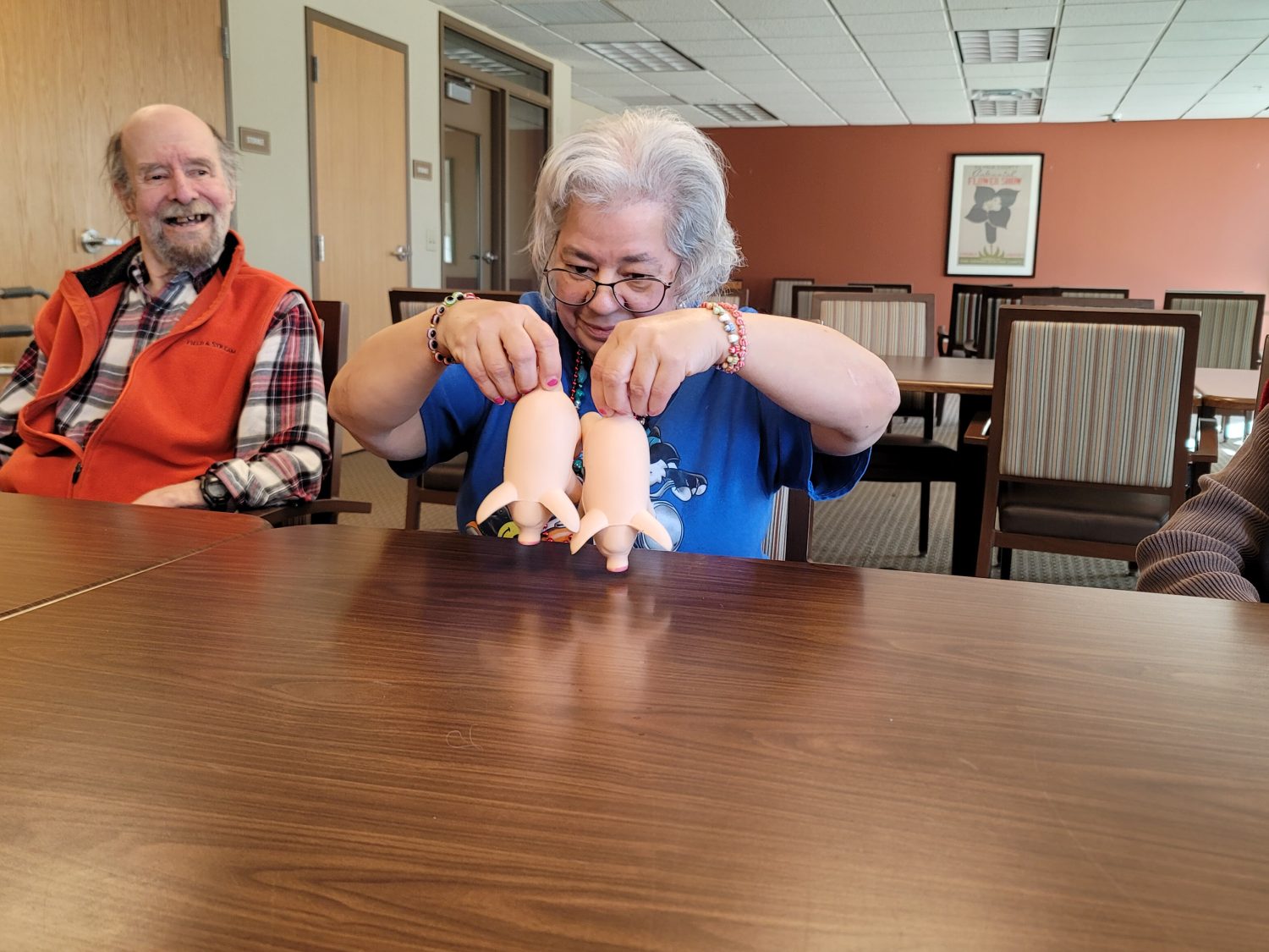 A resident playing with dolls at a table