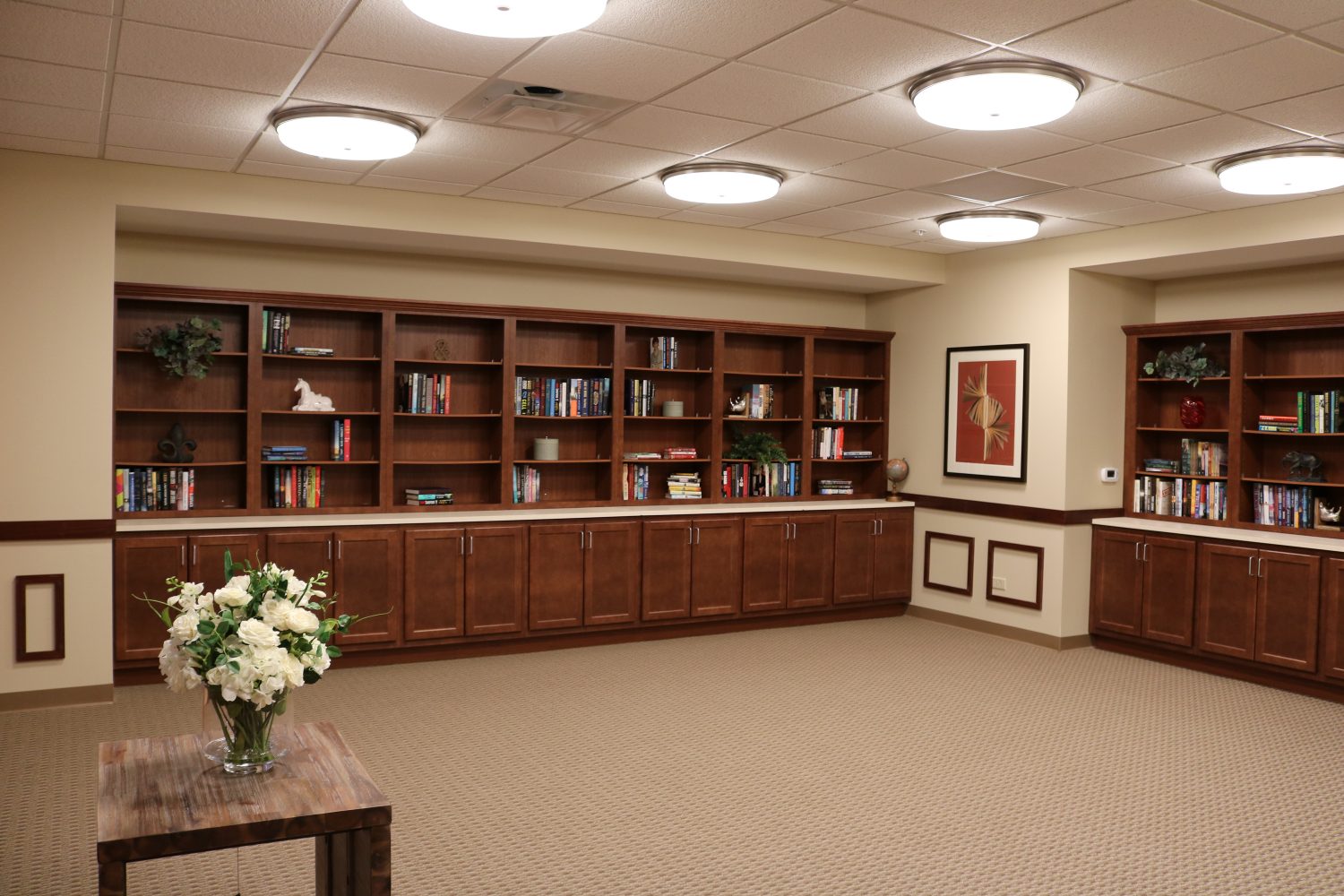 Cozy reading area with bookshelves and floral arrangement