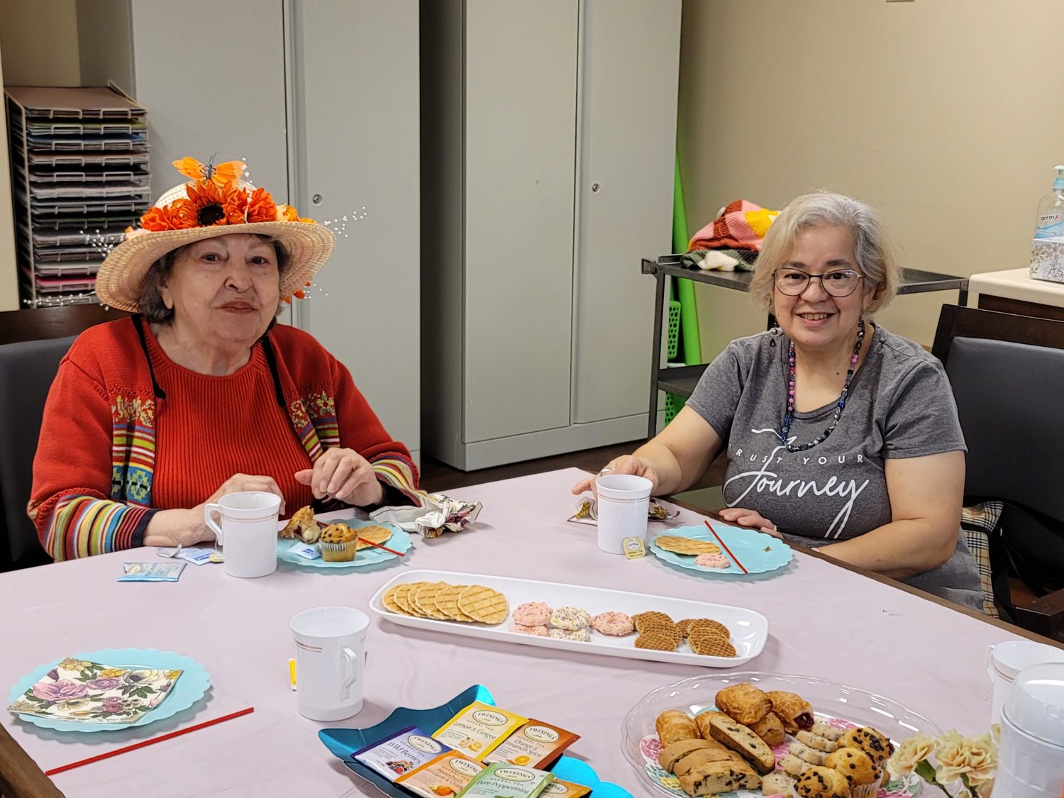 Two residents enjoying snacks at a table
