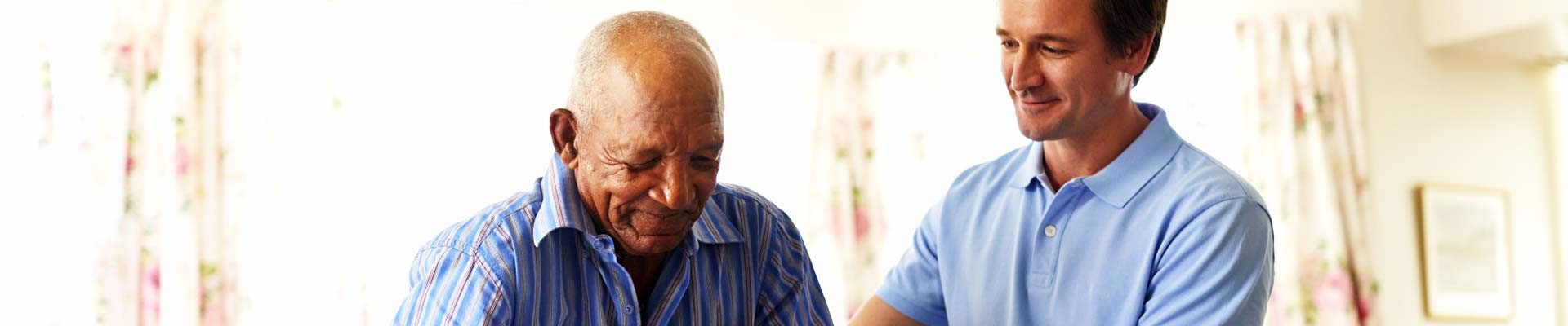A caregiver assisting an elderly resident indoors.