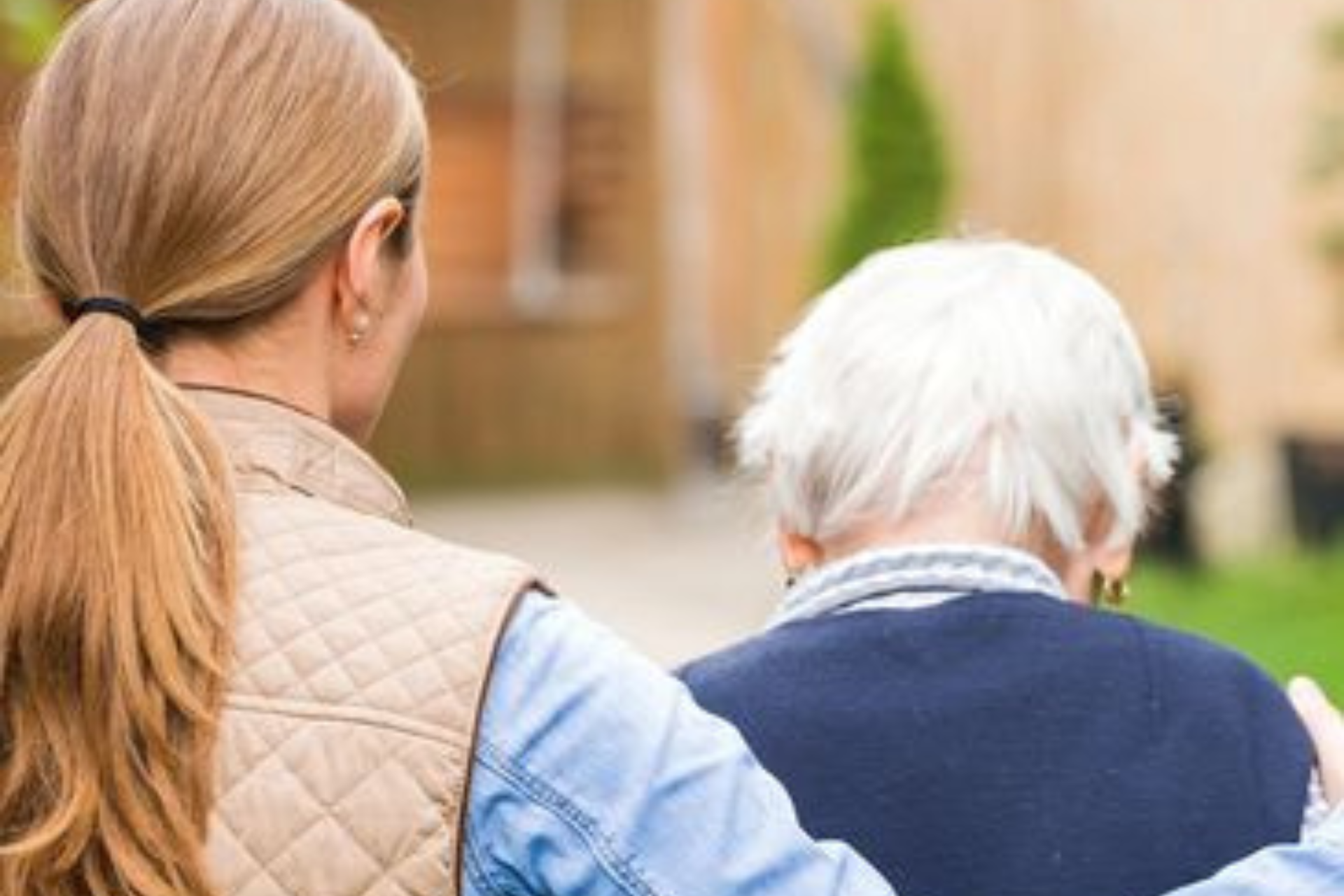 Caregiver assisting a senior outdoors.
