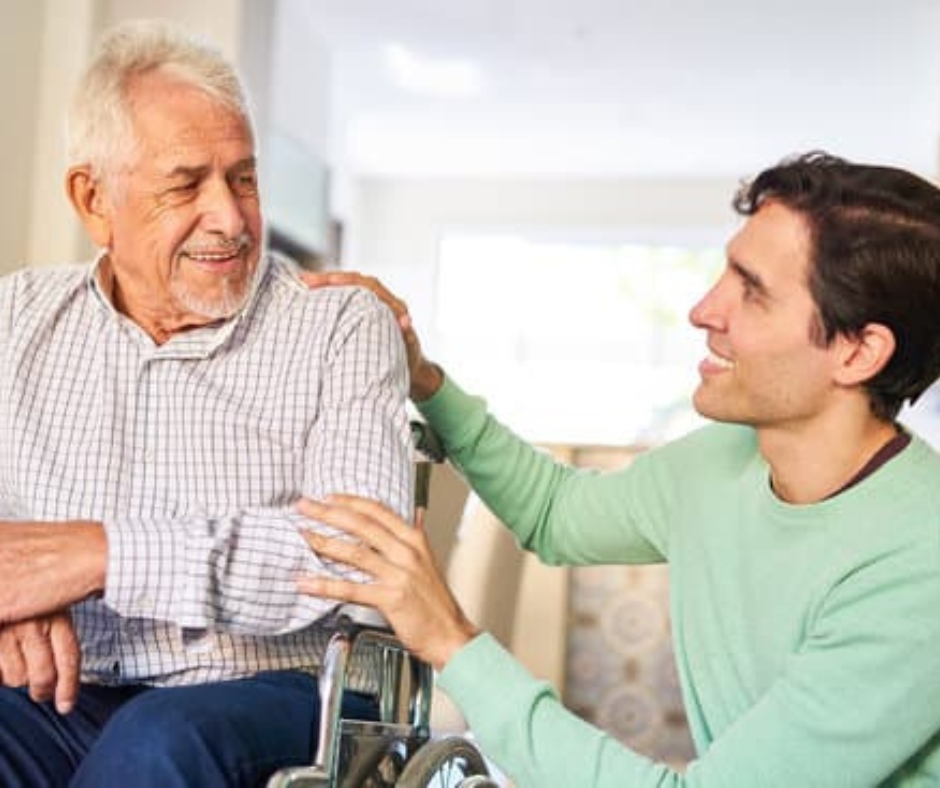 Senior man smiling with caregiver in common area