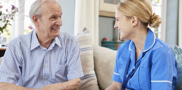 Caregiver interacting with a resident in a warm setting.