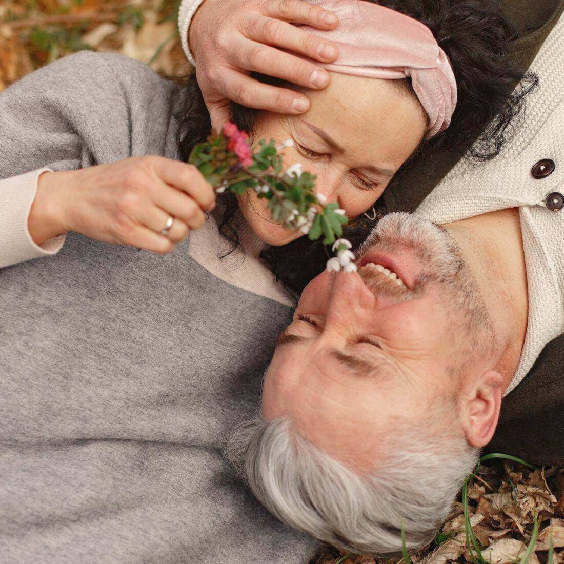 Two adults enjoying nature, smiling and laughing together.