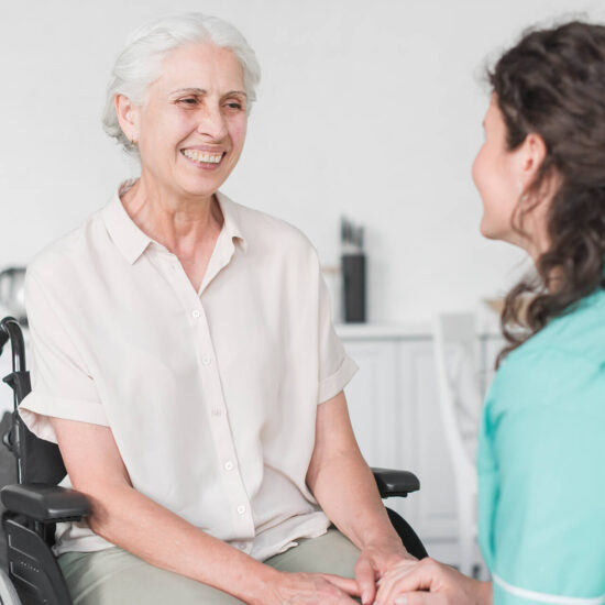 Smiling senior woman with caregiver in conversation