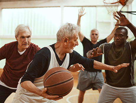 Seniors playing basketball indoors.