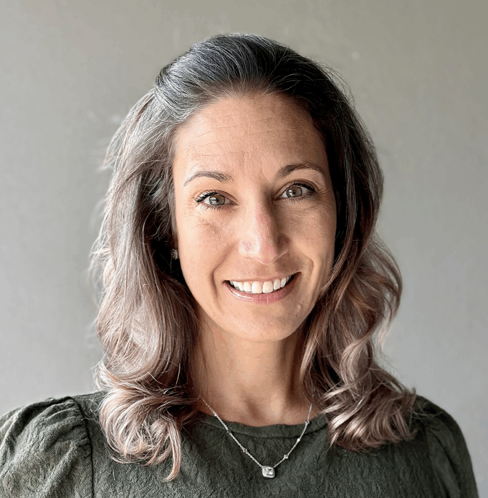 Smiling woman with gray hair looking at the camera.
