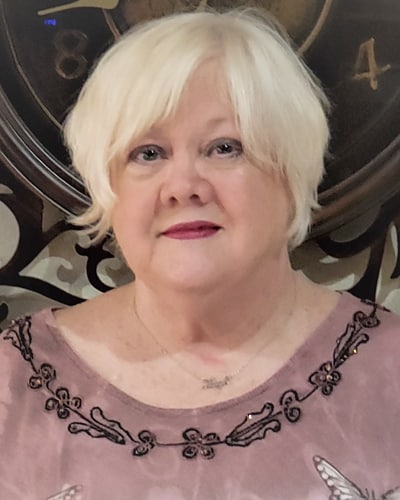 Smiling woman with blonde hair in a decorative interior