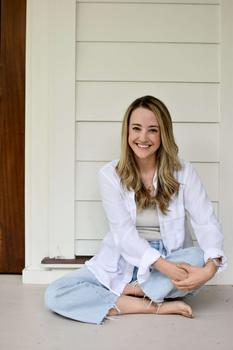 Young woman smiling while sitting on the floor.