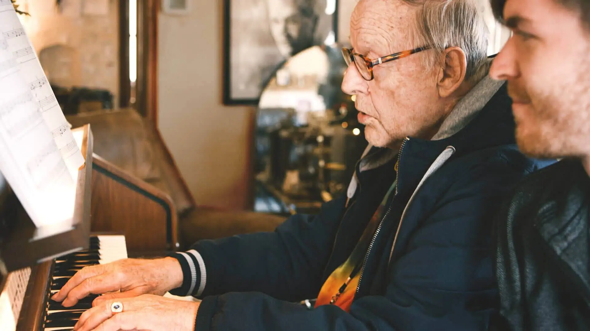 Senior playing piano with assistance