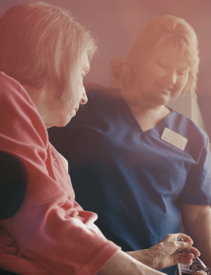 Caregiver assisting a resident in comfortable setting
