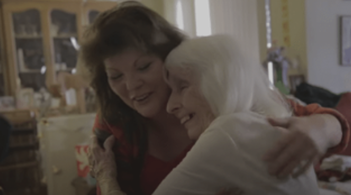 Resident and caregiver sharing a warm hug.
