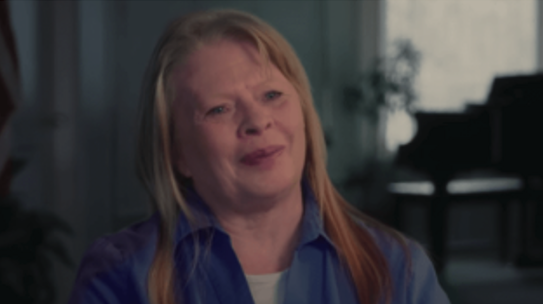A woman smiling during an interview indoors.