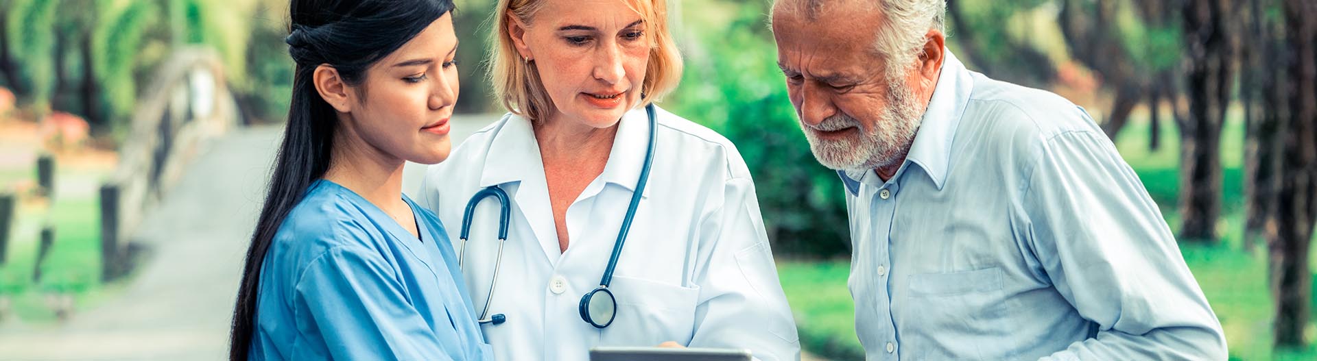 Healthcare staff assist a resident outdoors