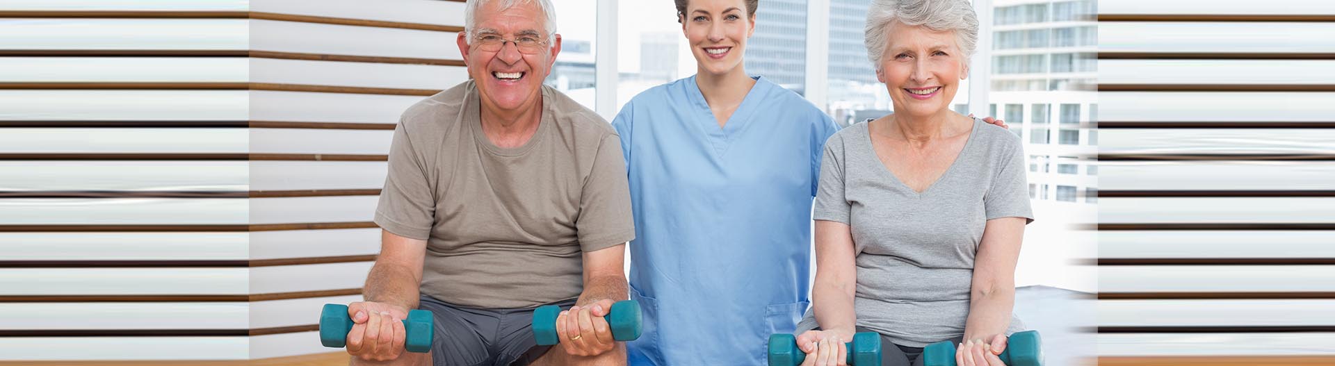 Seniors exercising with weights alongside a caregiver.
