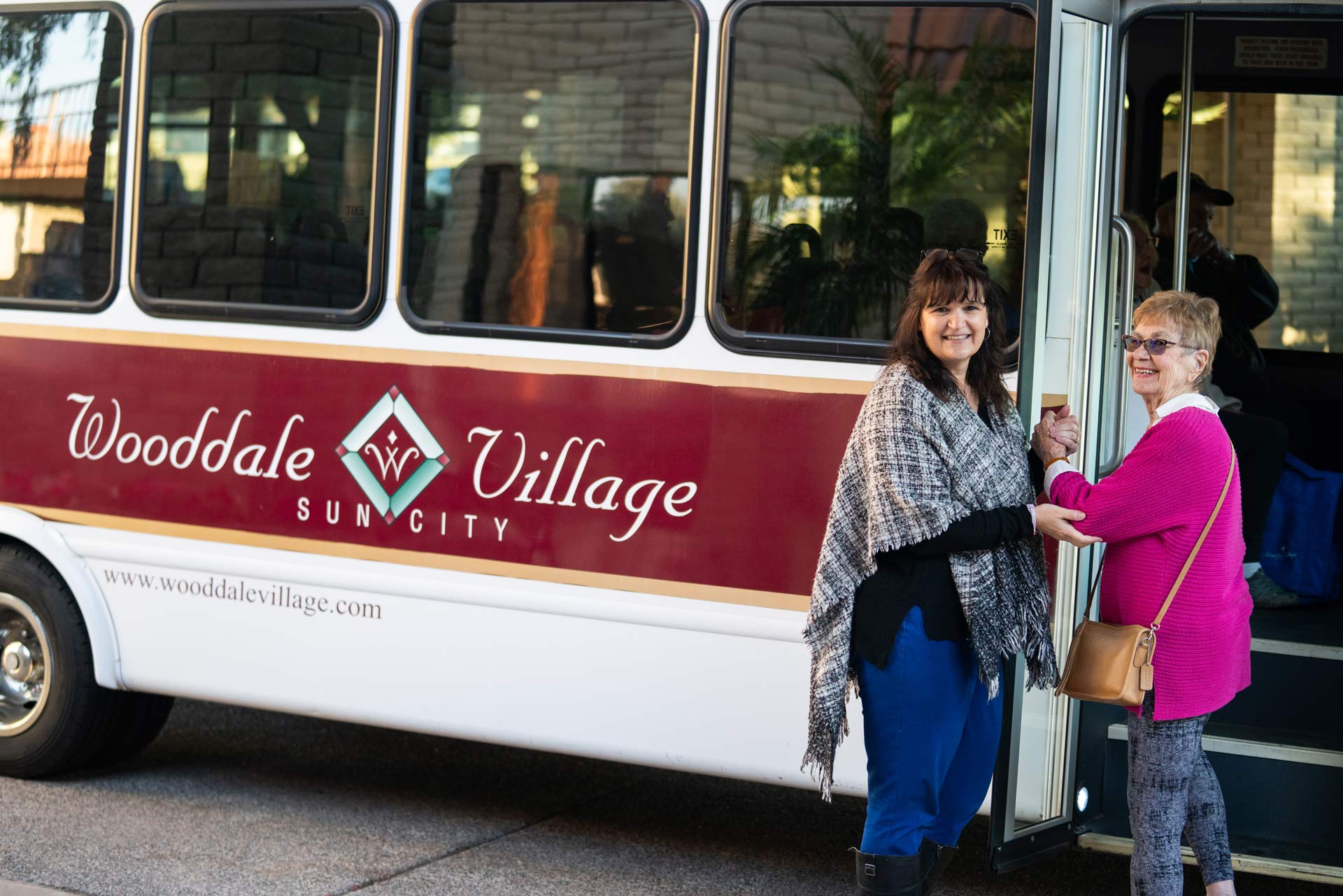 Two women boarding a facility transport bus