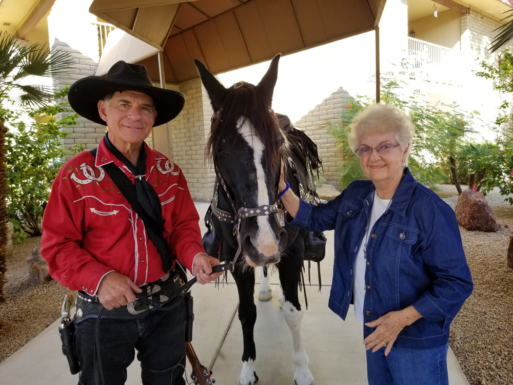Resident interacting with a cowboy and a horse outside