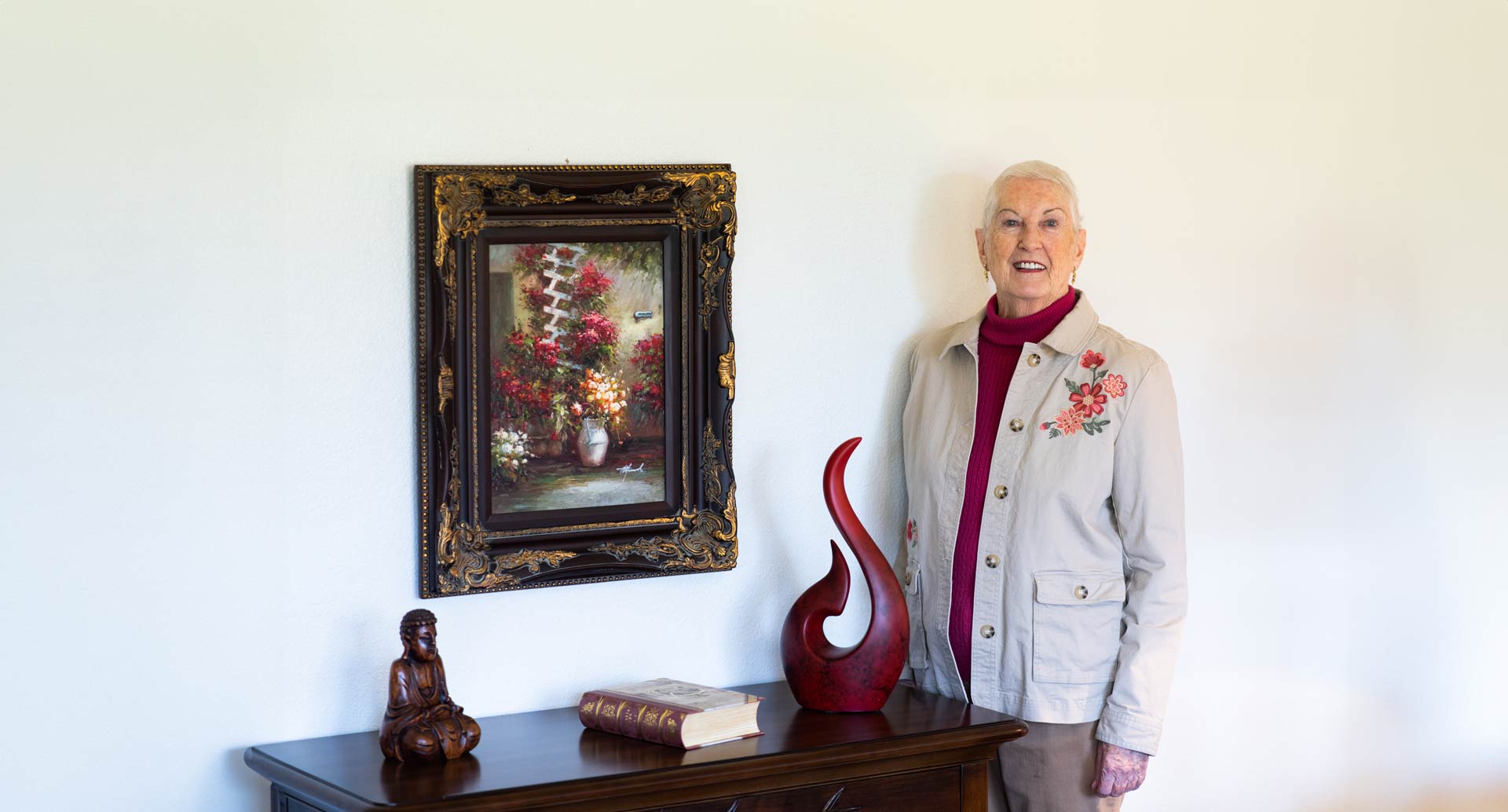 A resident standing next to a decorative wall.