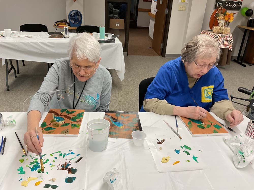 Residents painting in an activity room